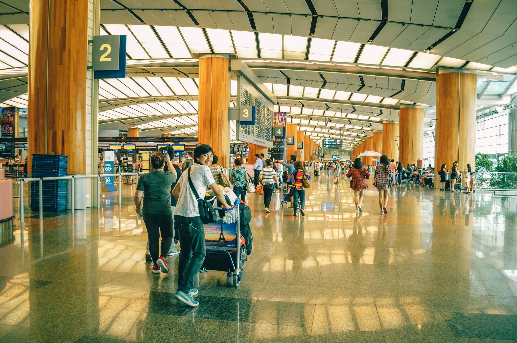 Travellers walking through a busy airport terminal concourse