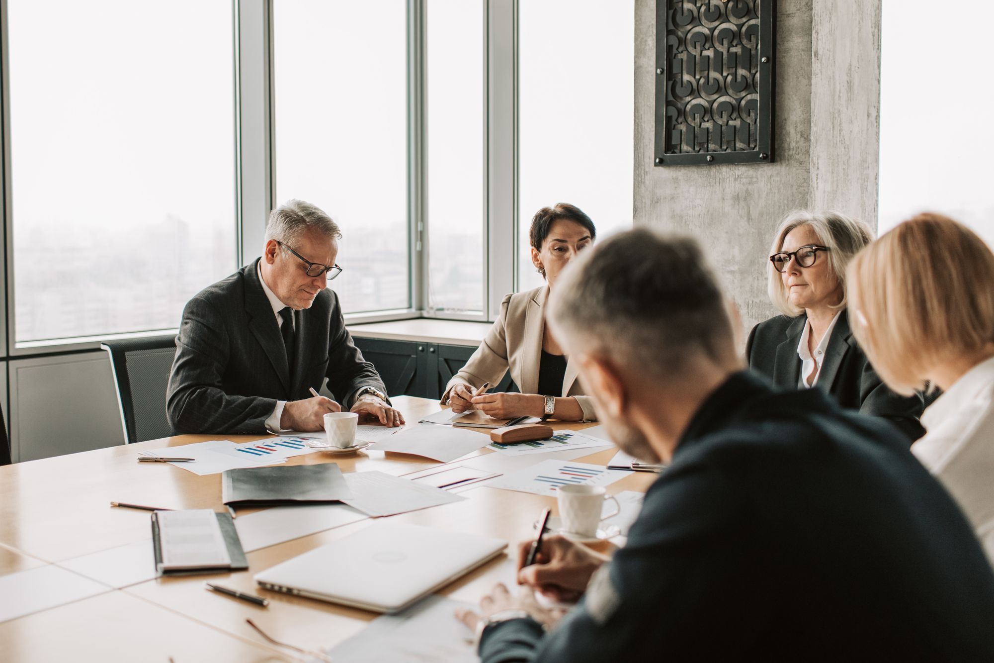 Executives reviewing documents together around a boardroom table